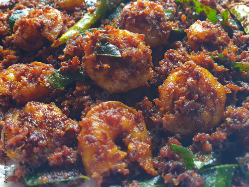 closeup shot of restaurent style fried prawns with red chilli and curry leaves