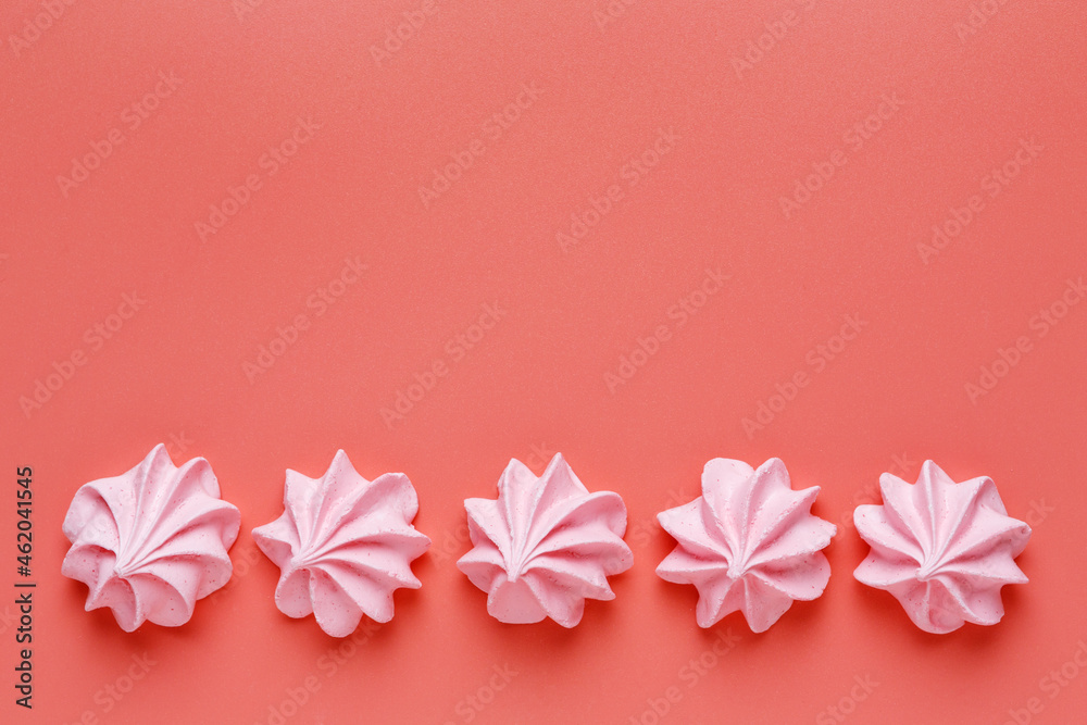 Pattern of pink meringues on a red background. Flat lay, Top view