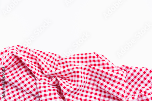 Checkers fabric crumpled top view with copy space. Red and white tablecloth texture picnic isolated on white background.
