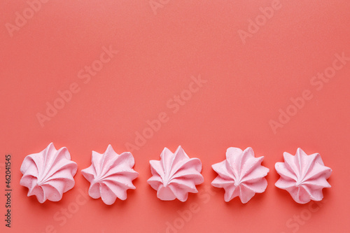 Pattern of pink meringues on a red background. Flat lay, Top view © Aleksandr Simonov