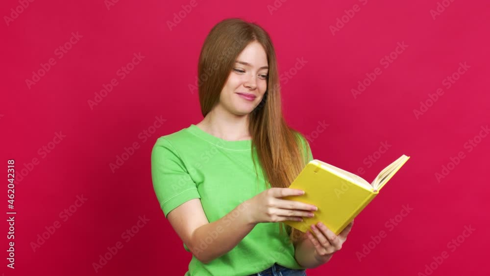 Teenager girl surprised and holding a book over isolated background Teenager girl surprised and holding a book over isolated background