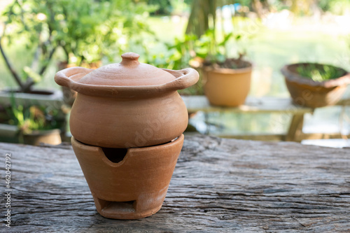 traditional Thai clay pottery placed on wooden table in garden