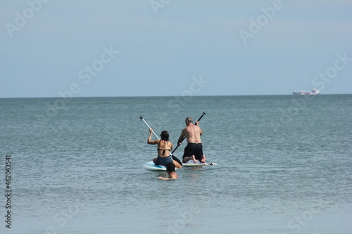 Família se divertindo no mar com pranchas de stand up