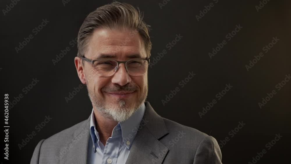 Business portrait - businessman smiling, pointing showing at blank space. Portrait of mature age, middle age, mid adult man in 50s, happy confident smile. Copy space. Business portrait - businessman smiling, pointing showing at blank space. Portrait of mature age, middle age, mid adult man in 50s, happy confident smile. Copy space.