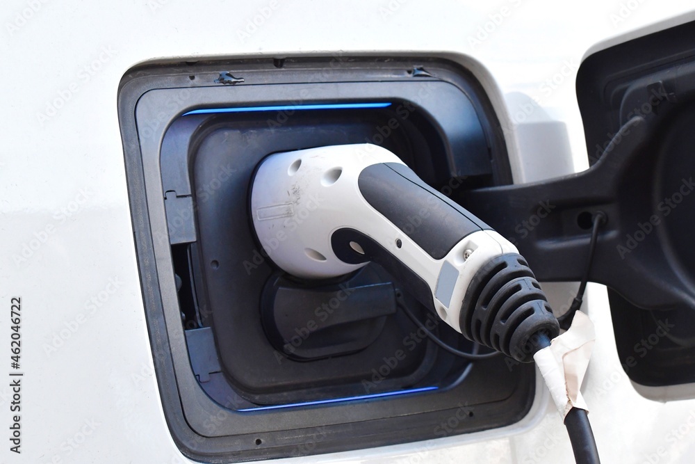 Closeup of a white electric car being charged Closeup of a white electric car being charged