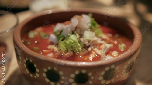 Clay bowl of delicious and traditional Mexican pozole photo