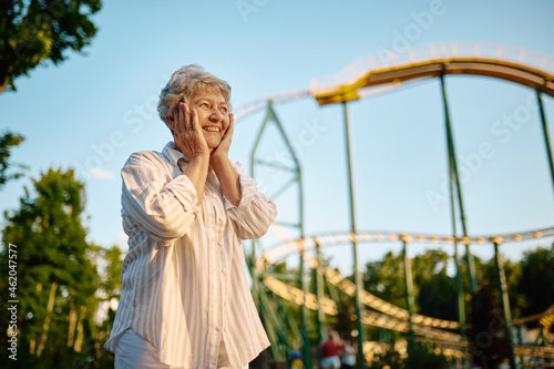 Pretty granny poses in summer amusement park