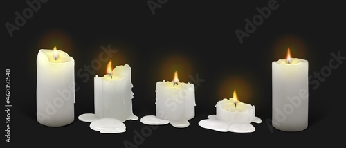Set of realistic burning white candles on a black background. 3d candles with melting wax, flame and halo of light. Vector illustration with mesh gradients. EPS10.