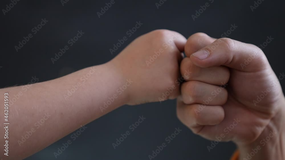 Father son fists together. Two fists together symbol of teamwork. Punching friendly greeting. Successful teamwork.Business contract greeting.Father and son fists together teamwork.Victory in business. Father son fists together. Two fists together symbol of teamwork. Punching friendly greeting. Successful teamwork.Business contract greeting.Father and son fists together teamwork.Victory in business.