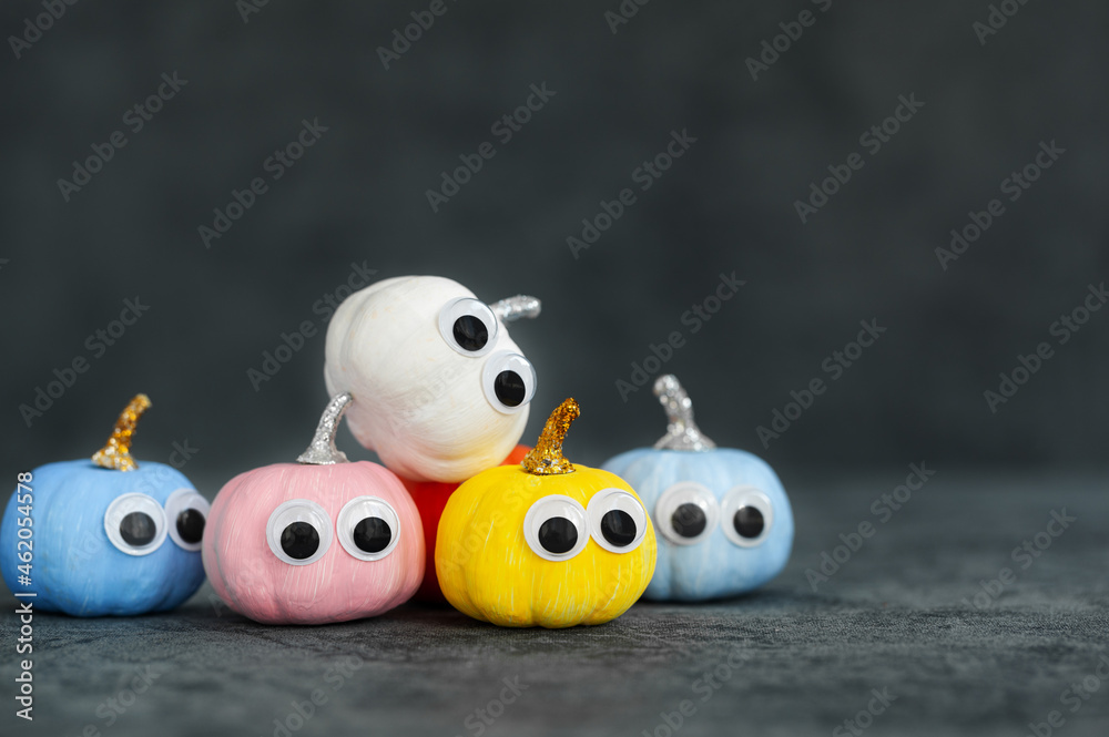 Bright colorful halloween funny face pumpkins on dark background with copy space. Greeting card for halloween. Bright colorful halloween funny face pumpkins on dark background with copy space. Greeting card for halloween.