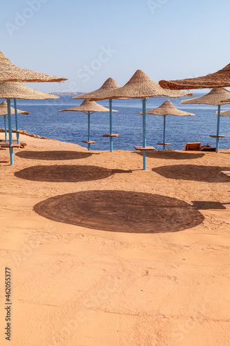 Beach straw umbrellas on the background of the blue sea. Beach Vacation © shandor_gor