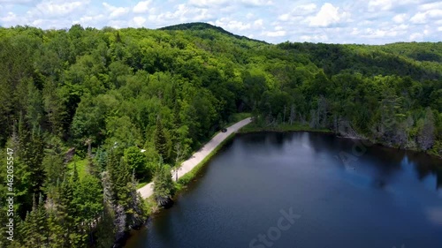 Wallpaper Mural Aerial view of a road through the green jungle forest with lakes and car driving through the forest, Adventure and travel ecosystem (Laurentides forest - Quebec) Torontodigital.ca
