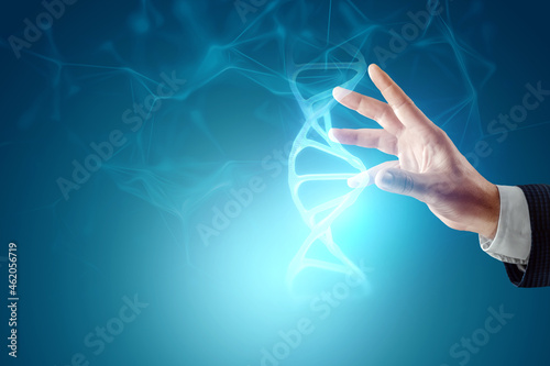 Glowing hologram of DNA molecule in the hand of a businessman on a blue background. Medical technology concept, science, biotechnology. Copy space.