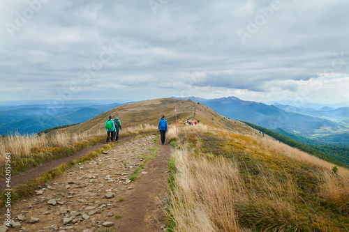 Fototapeta Naklejka Na Ścianę i Meble -  Bieszczady jesienią. Turyści na górskich szlakach. Połoniny. Ciemne chmury. Korory jesieni.