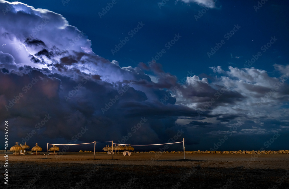 View of Large Storm Cloud Over Beach with mbrellas and Volleyball Corts View of Large Storm Cloud Over Beach with mbrellas and Volleyball Corts