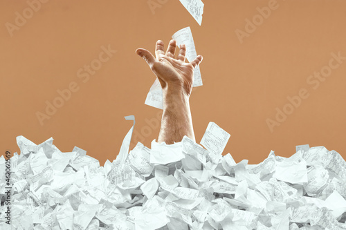 Bild auf Leinwand A man's hand sticks out of a mountain of checks and bills