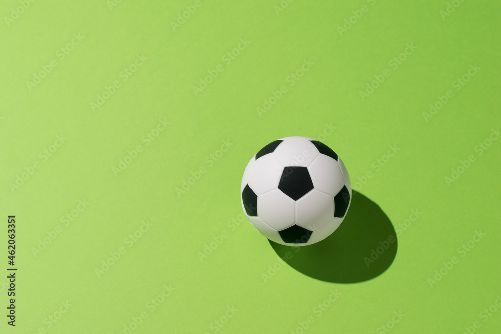 Soccer ball on a green background in bright light.