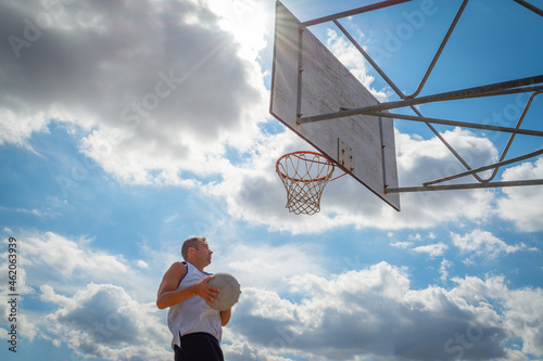 Player jumping to the hoop under a shining sun