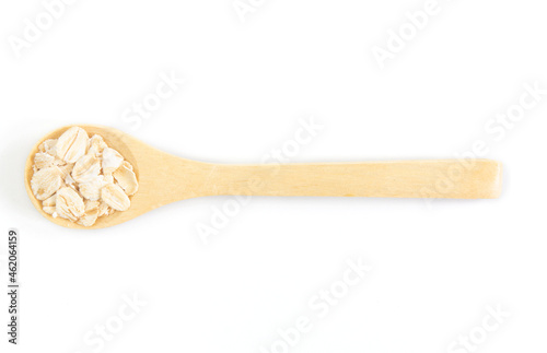 Top view of dry rolled oatmeal in wooden spoon isolated on white background.