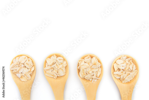 Top view of dry rolled oatmeal in wooden spoon isolated on white background.