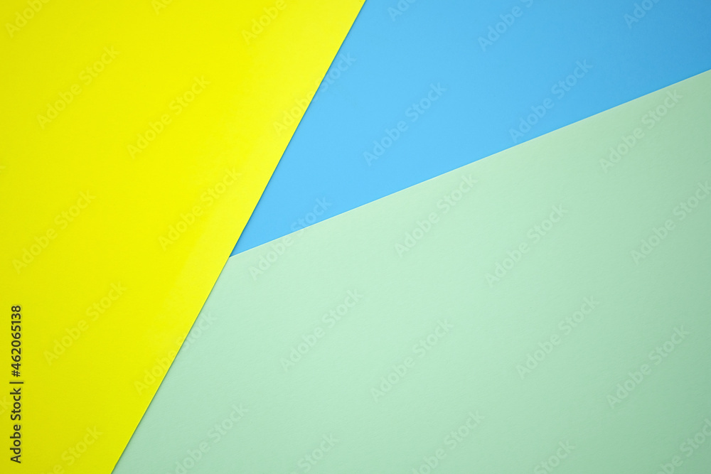 Abstract background from sheets of yellow, blue and green paper.  background with geometric shapes. Thick paper of different colors top view. Abstract paper - colorful background, creative design