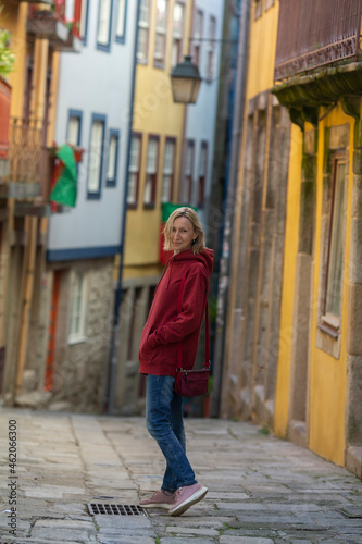 A woman in a hoodie posing an old Portuguese town. © De Visu