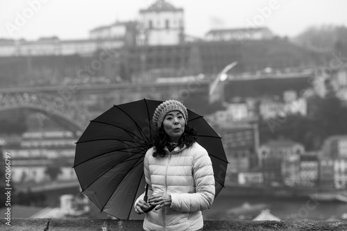 Young woman with an umbrella in Porto, Portugal. Black and white photo.