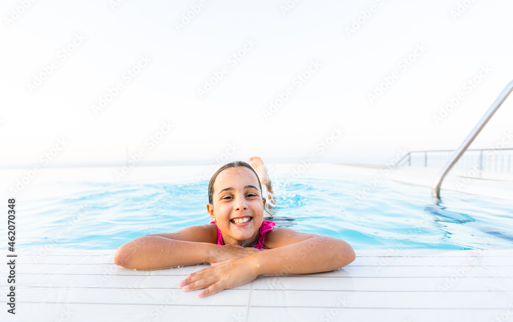 Closeup portrait of cute little arabic girl swimming in the pool, happy child having fun in water, beach resort, summer vacation and holidays concept