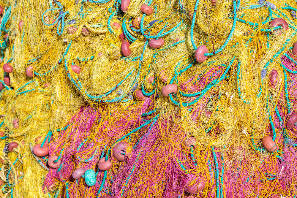 Close up macro image of old yellow red fishing net.