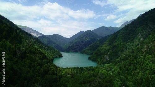 Aerial shot of beautiful alpine lake Ritsa , View from Above on Gorgeous Lake Ritsa between mountains in Nation Park, clear water, pristine nature. 4K UHD