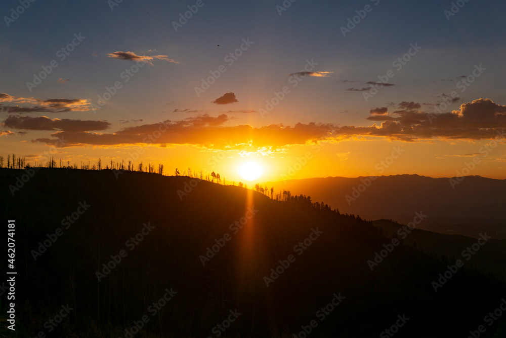 Obraz premium Stunning Golden Sunrise Over Silhouette Mountains