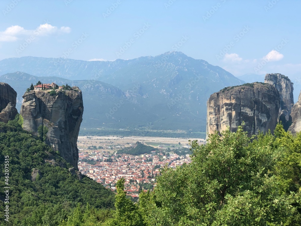 A view of rocky mountains with a small town between. Photography of the Meteora mountains, Calambaca village, Greece