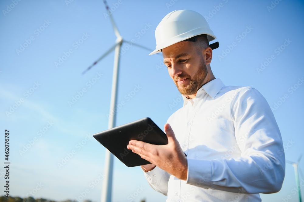 Engineer in wheat field checking on turbine production Engineer in wheat field checking on turbine production