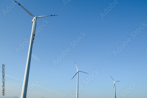 Wind Turbines in a Green Field and Blue Sky.