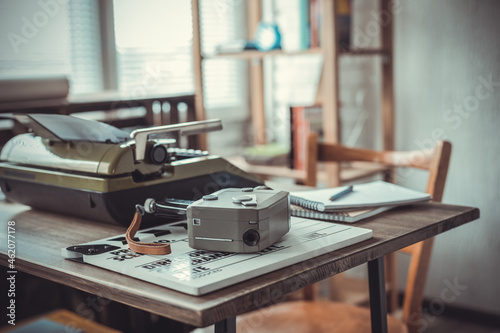 Vintage old film camera and typewriter at wooden desk table © Sergii Moscaliuk