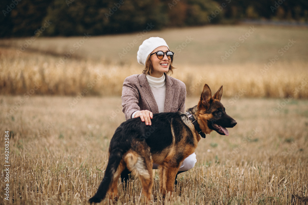 Beautiful woman walking out her dog in a field Beautiful woman walking out her dog in a field