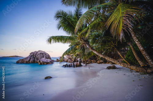 Sunset at tropical beach Anse Patates with granite boulders on La Digue Island, Seychelles