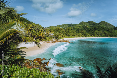 Mahe Island, Seychelles. Holiday vocation on the beautiful exotic Anse intendance tropical beach. Ocean wave rolling towards sandy beach with coconut palm trees