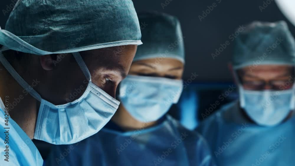 Multiracial team of professional medical surgeons performs the surgical operation in a modern hospital. Doctors are working to save the patient. Medicine, health, cardiology and transplantation. Multiracial team of professional medical surgeons performs the surgical operation in a modern hospital. Doctors are working to save the patient. Medicine, health, cardiology and transplantation.