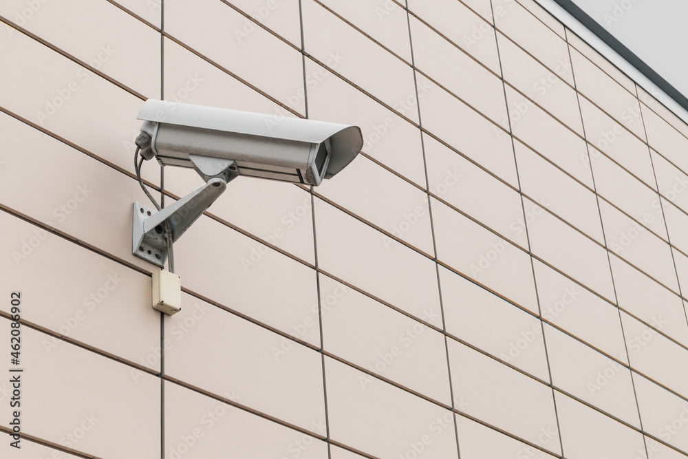 Close-up video surveillance camera on a bright building wall Close-up video surveillance camera on a bright building wall