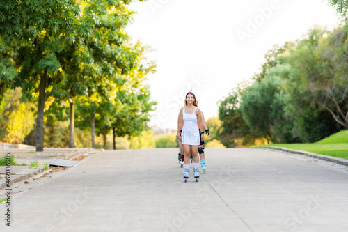 People skating in line in the middle of the street in a park