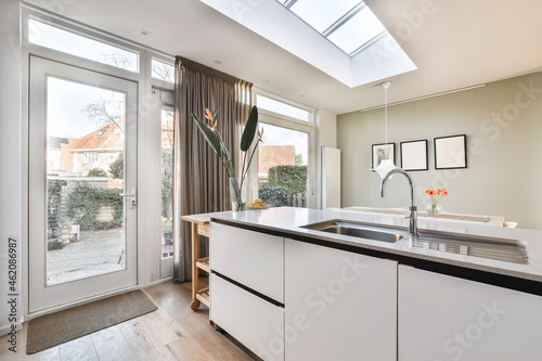 Interior shot of a modern kitchen with decorations and furniture next to an entrance photo