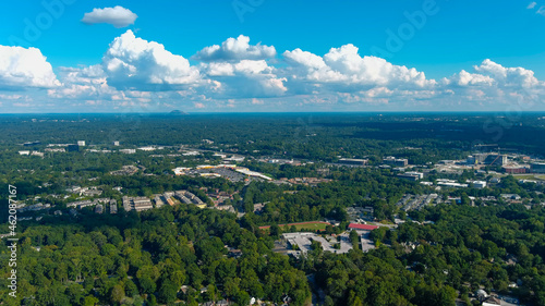 a stunning aerial shot of vast miles of lush green trees with a view of the buildings nestled in the trees and shot of the cityscape with blue sky and clouds at Lennox Park in Brookhaven Georgia USA photo