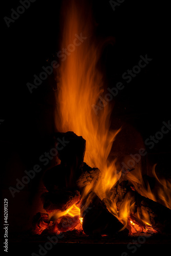 fire in fireplace  reddish and yellowish colors lighting glass of wine