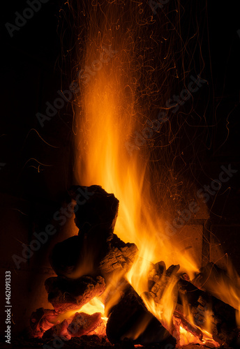 fire in fireplace, reddish and yellowish colors lighting glass of wine