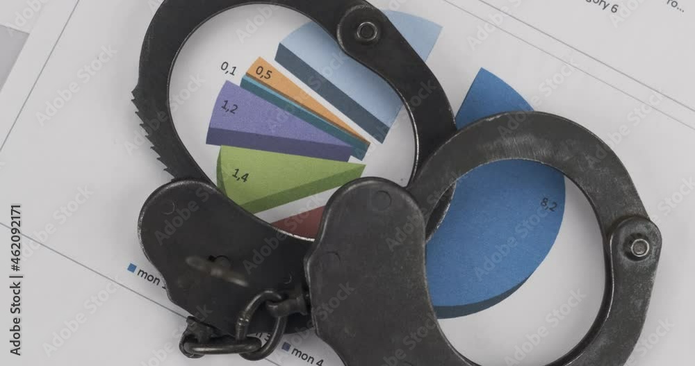 Rotation, iron handcuffs lying on the color chart. Crime and Punishment