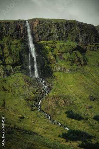 Waterfall in green mountains in Iceland. Beautiful nature landscape in the day