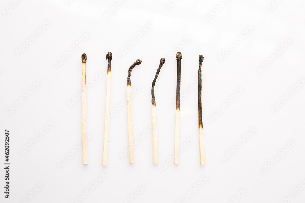 six burnt wooden matches on white background