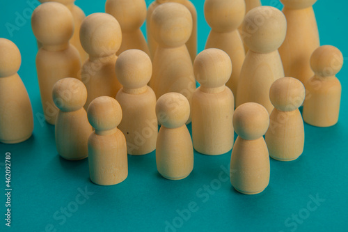  Grouping of wooden chips in the shape of people of different heights as a demonstration or meeting