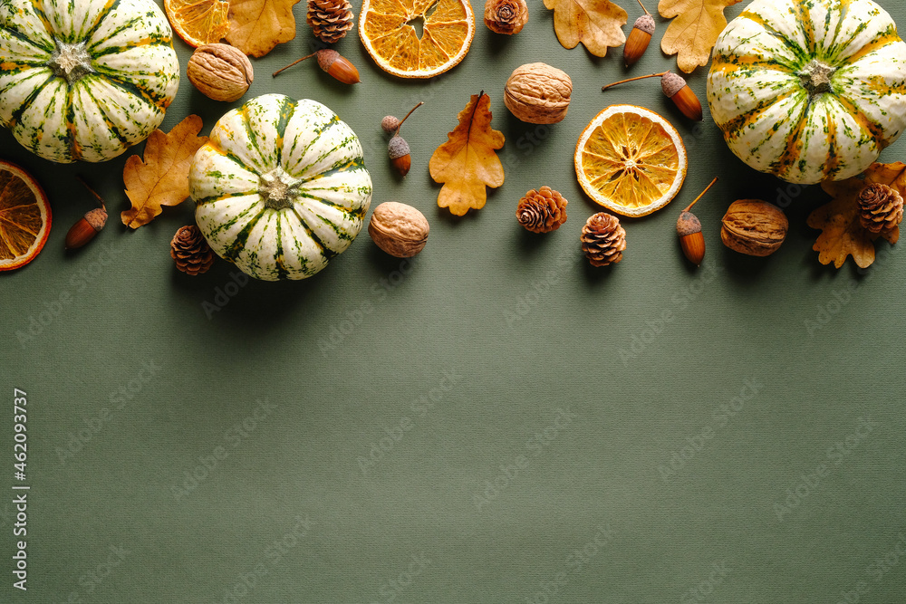 Autumn composition. Flat lay pumpkins, fallen oak leaves, dry oranges, acorns on vintage green background. Thanksgiving day greeting card design. Autumn composition. Flat lay pumpkins, fallen oak leaves, dry oranges, acorns on vintage green background. Thanksgiving day greeting card design.